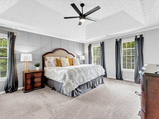 carpeted bedroom featuring a textured ceiling, baseboards, and a ceiling fan