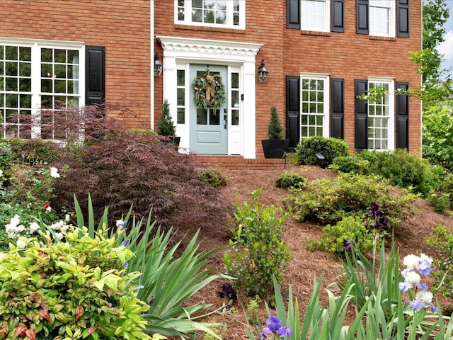 doorway to property featuring brick siding