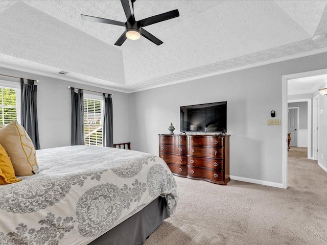 bedroom featuring a textured ceiling, multiple windows, crown molding, carpet floors, and a raised ceiling
