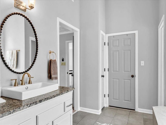 bathroom with baseboards, vanity, and tile patterned floors