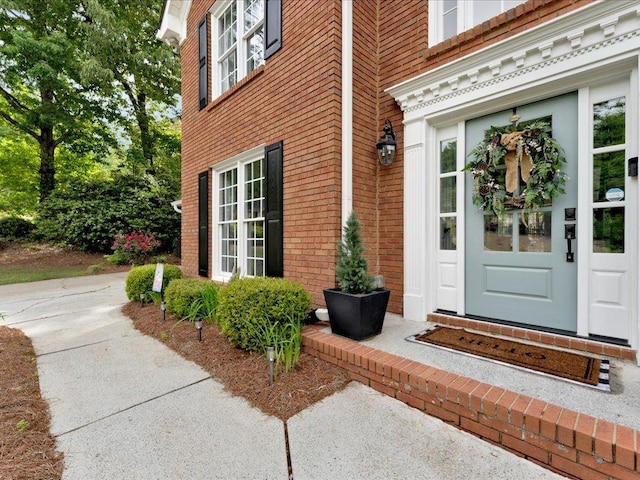 doorway to property featuring brick siding