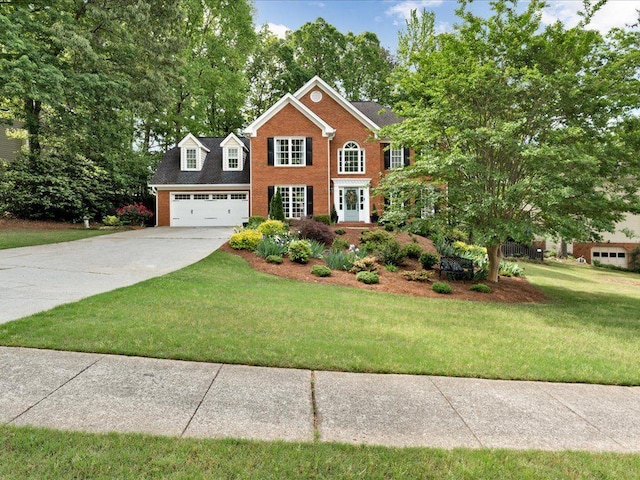 view of front of property featuring brick siding, driveway, a front lawn, and a garage