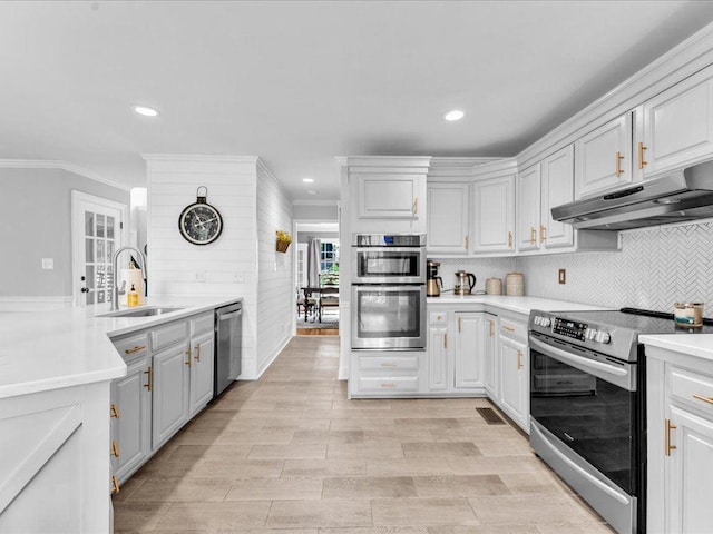 kitchen featuring appliances with stainless steel finishes, under cabinet range hood, a sink, crown molding, and light countertops