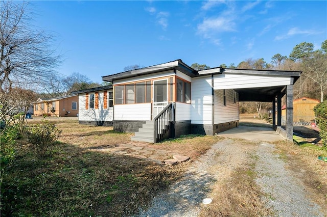 view of side of home with a carport and a sunroom