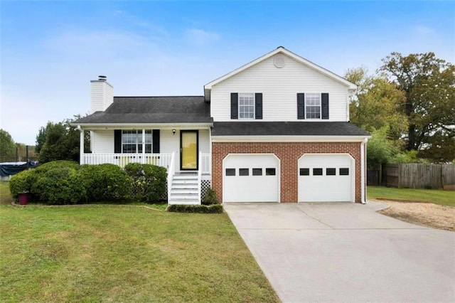 split level home with covered porch, a garage, and a front lawn