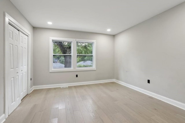 unfurnished bedroom featuring a closet and light wood-type flooring