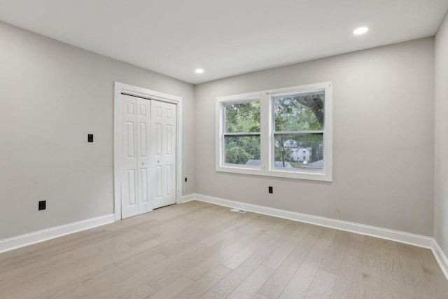 unfurnished bedroom featuring a closet and light hardwood / wood-style flooring