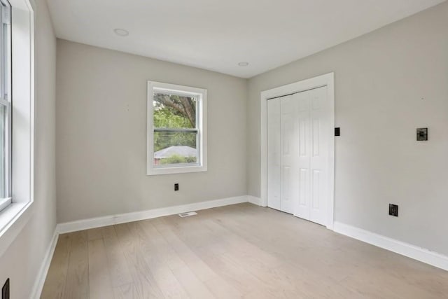 unfurnished bedroom featuring light hardwood / wood-style floors and a closet