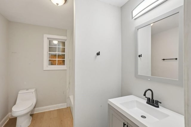 bathroom featuring wood-type flooring, toilet, and vanity