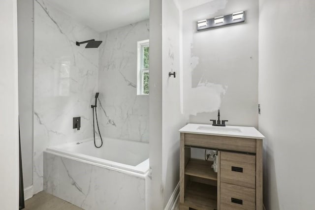 bathroom featuring tiled shower / bath and vanity