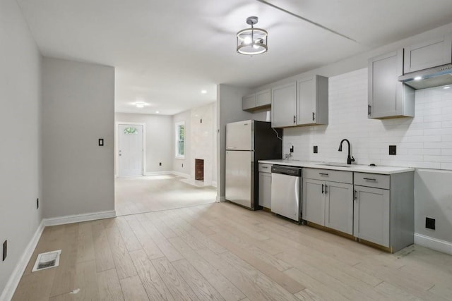 kitchen with refrigerator, gray cabinets, dishwasher, and sink