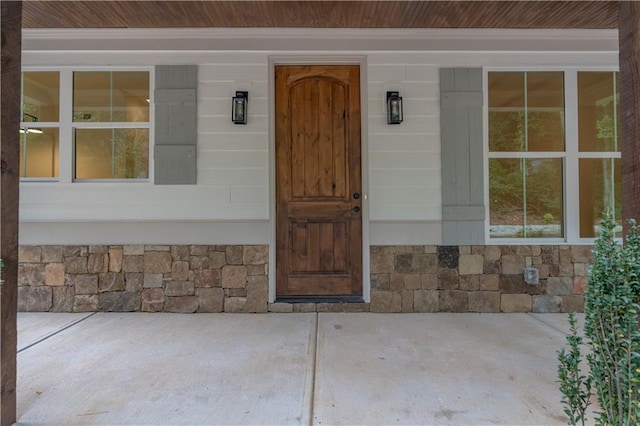 view of exterior entry featuring covered porch