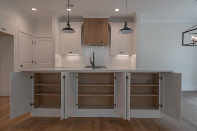 kitchen with light hardwood / wood-style flooring, white cabinets, pendant lighting, and ornamental molding