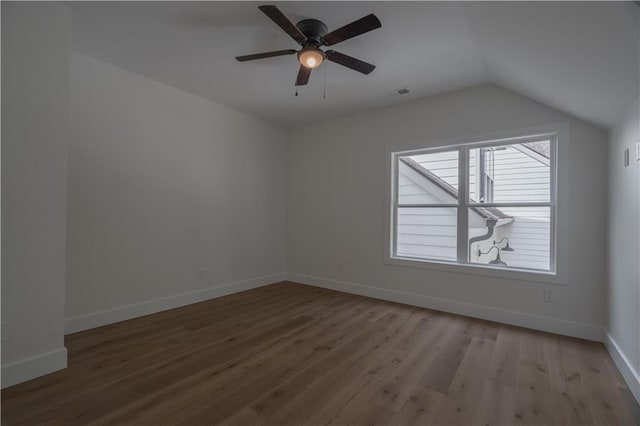 empty room with ceiling fan, light hardwood / wood-style flooring, and vaulted ceiling