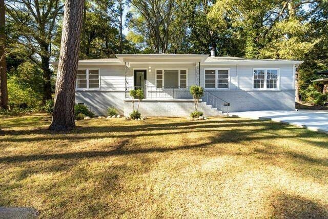 single story home with a front yard and covered porch