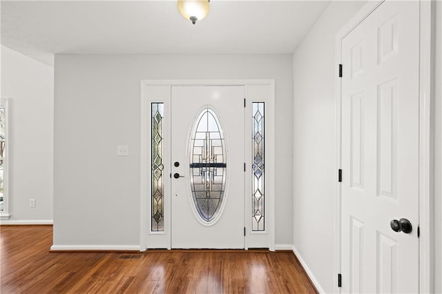 entryway with baseboards and wood finished floors