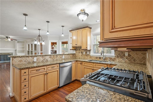 kitchen with appliances with stainless steel finishes, dark hardwood / wood-style floors, sink, hanging light fixtures, and kitchen peninsula