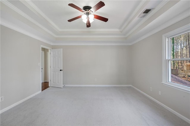 spare room with light carpet, baseboards, and a tray ceiling