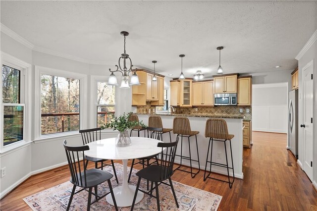 kitchen featuring appliances with stainless steel finishes, tasteful backsplash, sink, dark hardwood / wood-style flooring, and light stone countertops