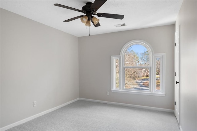 spare room with light colored carpet, visible vents, and baseboards