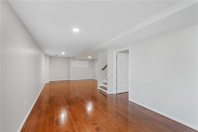 spare room with recessed lighting, baseboards, hardwood / wood-style floors, and stairs