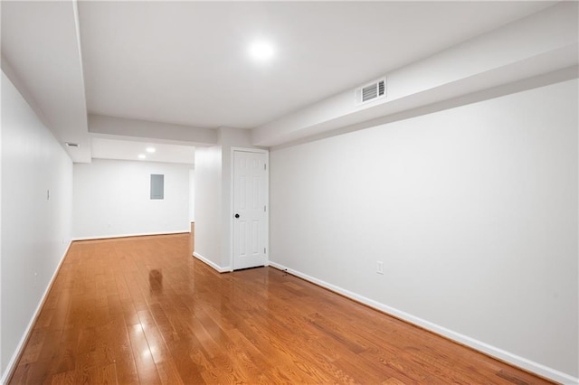 finished below grade area featuring wood finished floors, visible vents, and baseboards