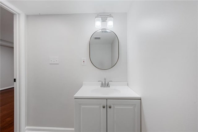 bathroom featuring baseboards, wood finished floors, and vanity