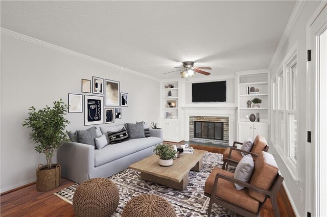 unfurnished living room featuring crown molding, built in features, ceiling fan, hardwood / wood-style floors, and a fireplace