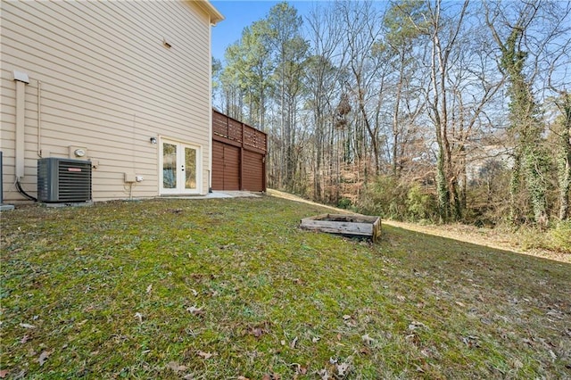 view of yard with cooling unit, french doors, and a wooden deck