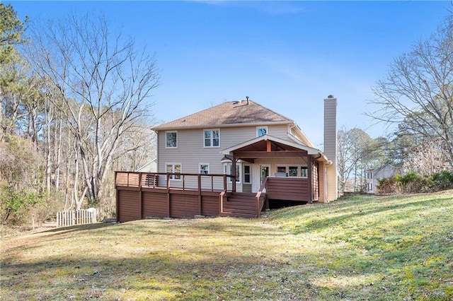 back of property with a yard, a chimney, a wooden deck, and fence