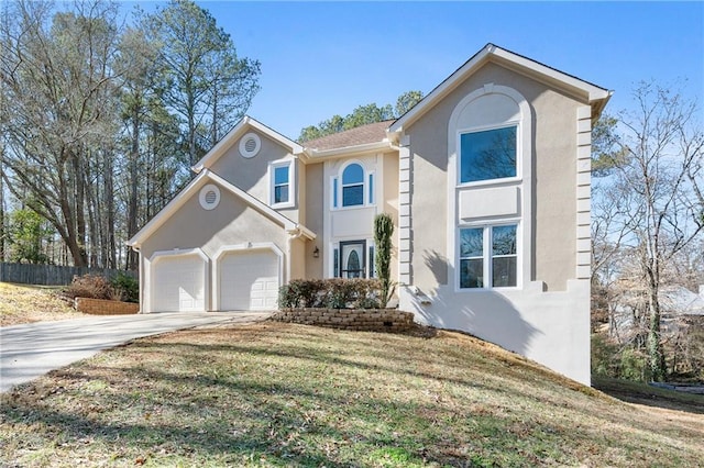 traditional-style house featuring a front yard, driveway, an attached garage, and stucco siding