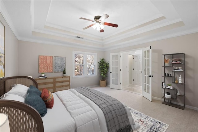 bedroom featuring visible vents, a tray ceiling, crown molding, and french doors