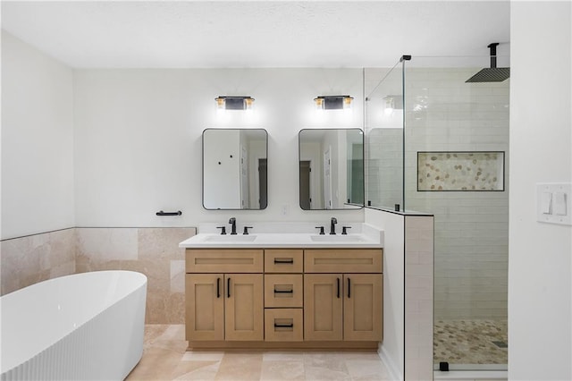 bathroom featuring a freestanding bath, a stall shower, and a sink