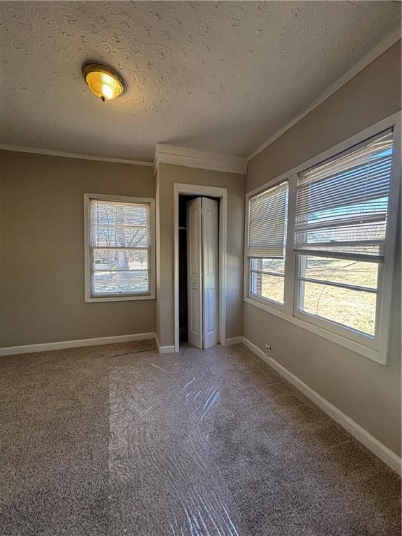 2103 River Rd, Ellenwood, GA 30294 - unfurnished bedroom with ornamental molding, multiple windows, a closet, a textured ceiling, and light carpet