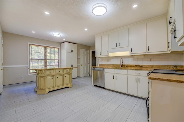 kitchen with a kitchen island, a sink, white cabinets, stainless steel dishwasher, and backsplash