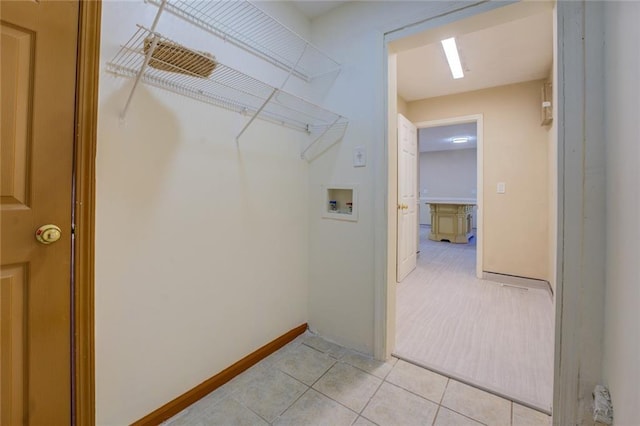 laundry room with laundry area, baseboards, light tile patterned floors, and washer hookup