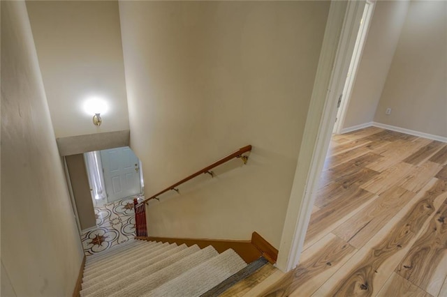 stairway featuring baseboards and wood finished floors