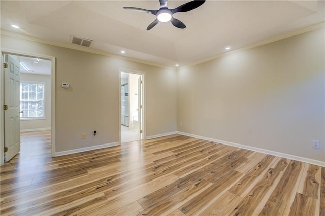 unfurnished room featuring ornamental molding, light wood-style flooring, visible vents, and baseboards