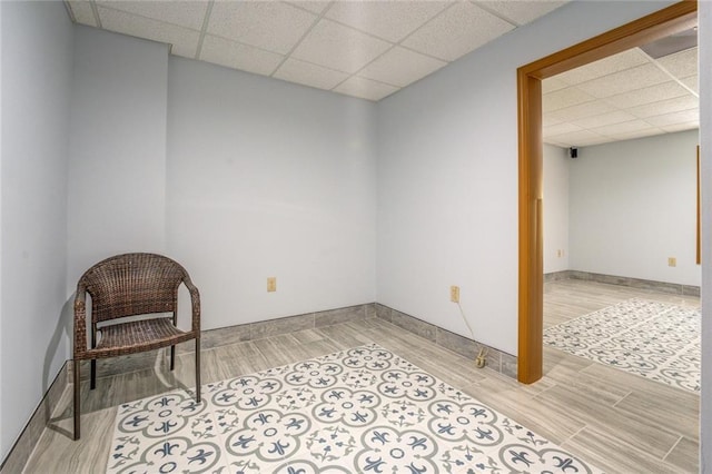 sitting room with a paneled ceiling, wood tiled floor, and baseboards