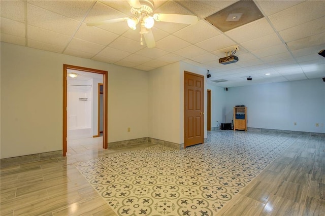 unfurnished room with light wood-style flooring, baseboards, and a drop ceiling