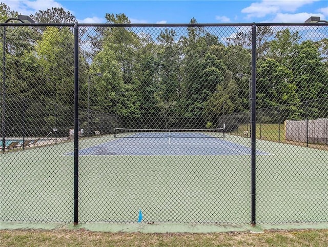 view of tennis court with fence