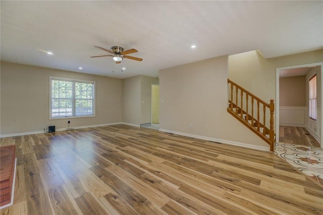 empty room featuring stairs, ceiling fan, light wood-style flooring, and recessed lighting