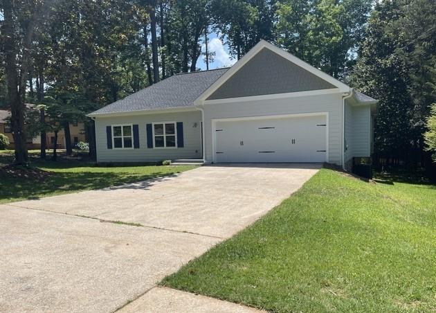 ranch-style house with a garage and a front lawn