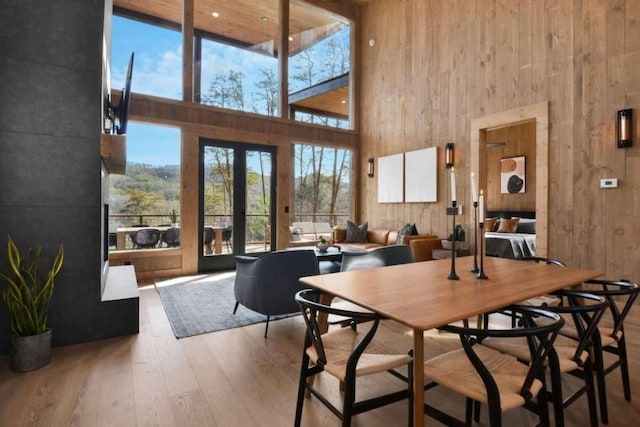 dining space with hardwood / wood-style flooring, french doors, and a high ceiling