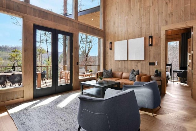 living room with a towering ceiling, a wealth of natural light, and hardwood / wood-style flooring