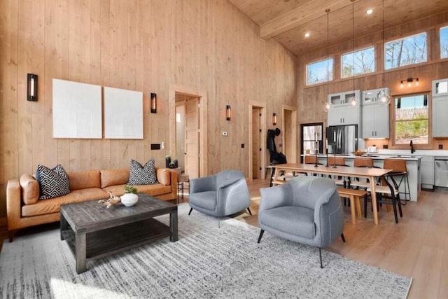 living room with sink, a high ceiling, wood-type flooring, wooden ceiling, and beamed ceiling