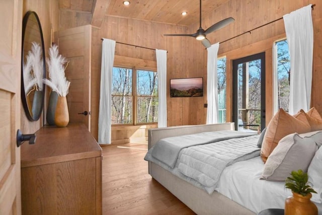 bedroom with wood ceiling, ceiling fan, wooden walls, and light hardwood / wood-style flooring