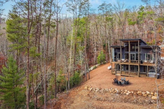 back of house featuring an outdoor fire pit and a deck