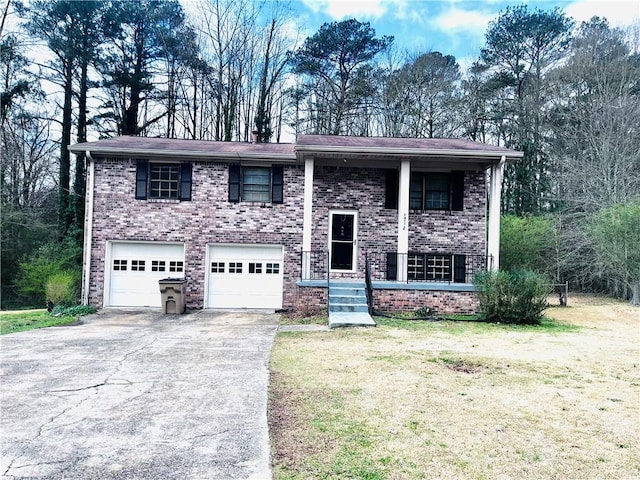 raised ranch with driveway, a front lawn, and brick siding