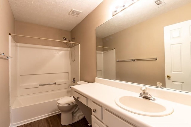 full bathroom featuring toilet, a textured ceiling, visible vents, and wood finished floors